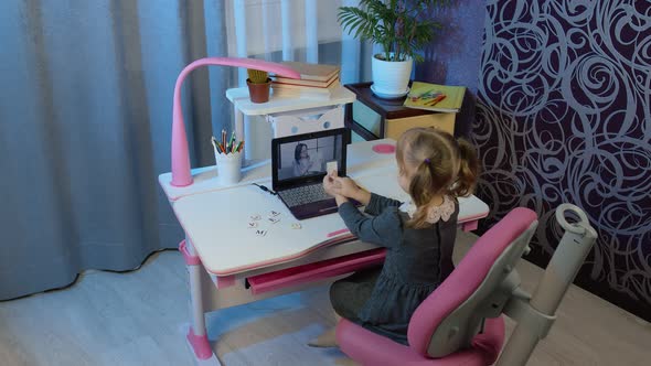 Child Pupil Schoolgirl Learns Lessons with Woman Teacher Being at Home Using Digital Laptop Computer alt