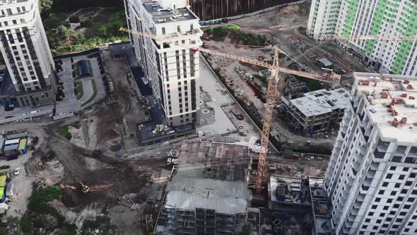 Top view of construction site with cranes and unfinished buildings in forest alt