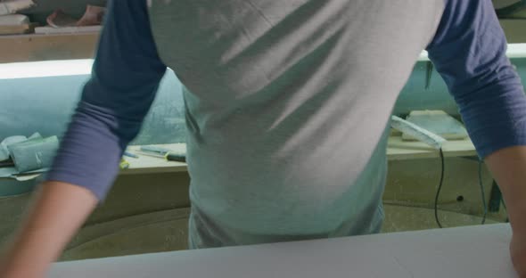 Portrait of male surfboard maker in his workshop alt