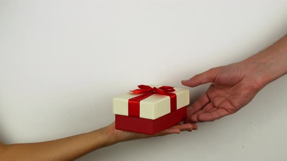 Woman hand holding a present for Merry Christmas. New Year and Christmas gifts in bright boxes alt