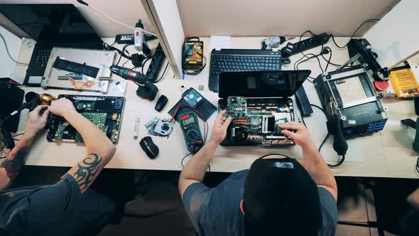 Top View Service Technicians Repairing Laptops alt