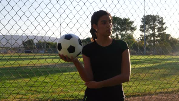 A strong and confident female athlete soccer player holding a football during a competitive womens s alt