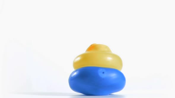 Yellow balloon rebounding in super slow motion on a blue one alt