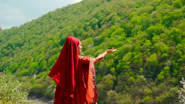 A Girl in a National Georgian Red Dress is Dancing alt