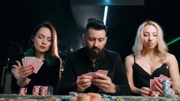 A Sad Bearded Man and Two Girls Are Loses To a Card Game at a Casino alt