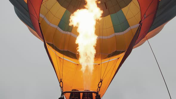 Travelers Inflate the Balloon with Warm Air and Prepare To Fly in a Balloon Above the Clouds alt