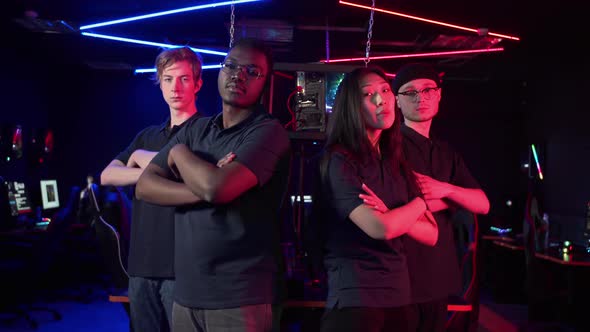 The Cyber Team Consisting of Three Guys and a Girl Confidently Looks at the Camera and Folds a Arms alt