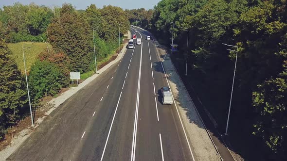 New road with four lines and the cars going by in summer alt
