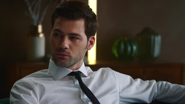 Businessman Sitting on Couch in Office Interior, Professional Looking at Camera alt