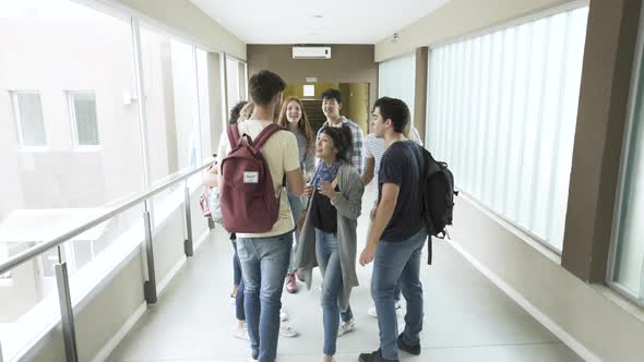 Group of students taking selfie with smartphone in corridor