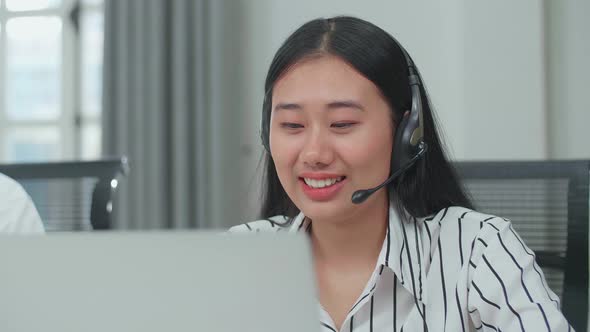 Asian Woman And Man Call Centre Agents Wearing Headset Speaking To A Customer alt