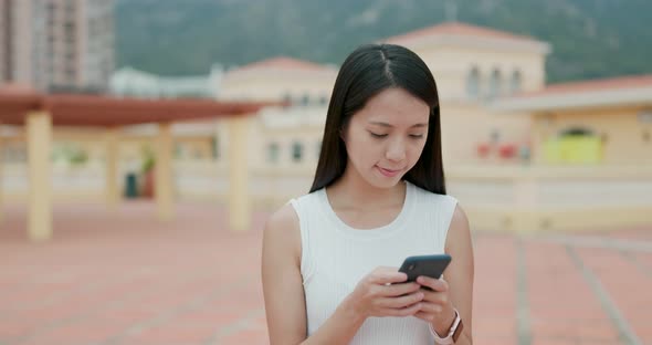 Woman use of mobile phone in city alt