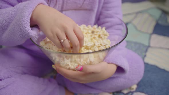 Close Up of Asian Woman Eating Popcorn While Watching Movie or Tv Show alt