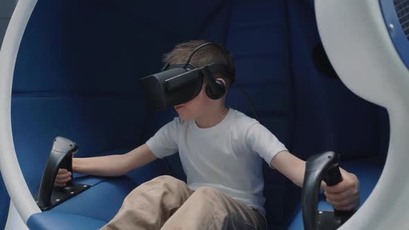 Boy in a Virtual Reality Headset in a Moving Interactive Chair