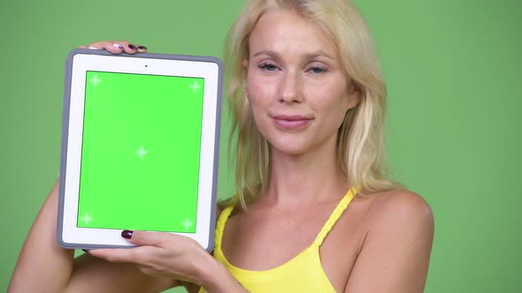 Young Happy Beautiful Blonde Woman Showing Digital Tablet