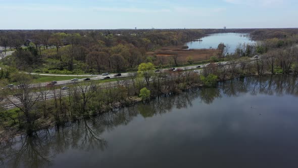 An aerial view of some reflective lakes during the day. The drone camera truck right as it booms up alt