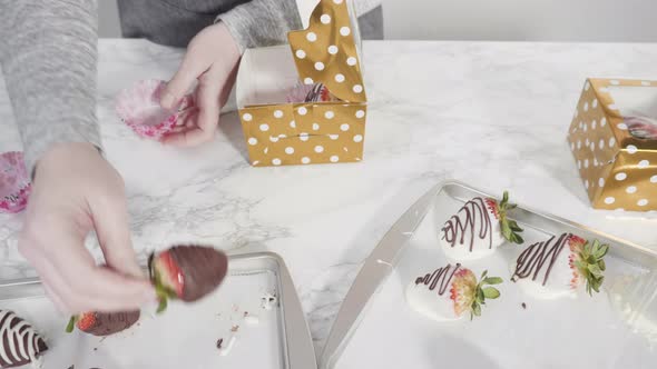Step by step. Packaging chocolate dipped strawberries into a paper box for a gift. alt