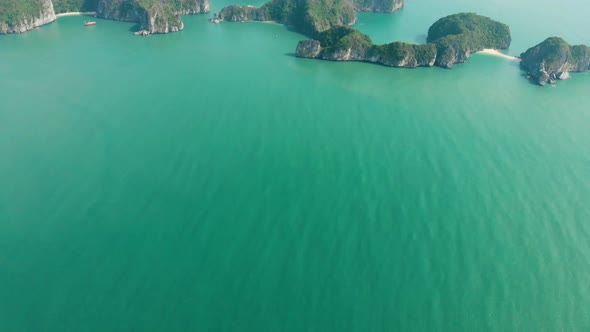 Aerial: flying over Ha Long Bay rock pinnacles, famous tourism destination in Vietnam alt