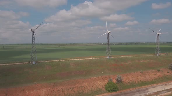 Aerial view of wind turbines energy production and road on fields