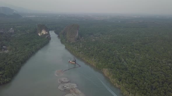 Aerial view of Krabi town Tara river in Thailand. Trees, green limestone rocks near river.