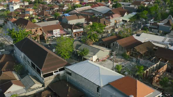 motorbikes and traffic driving during sunrise in bali indonesia, aerial alt