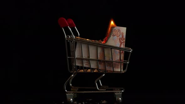 Russian Money Burns in a Trolley From the Supermarket on a Black Background