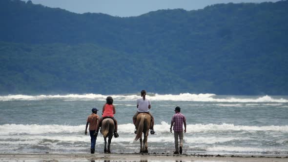 Family Riding Horses on the Seashore