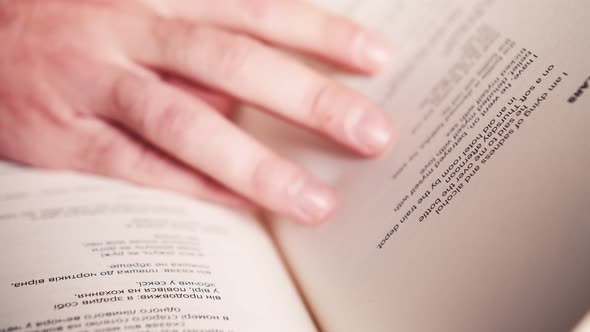 Hand Turning Pages of a Book, CLOSE UP. SLOW MOTION. Unrecognizable Person's Hand Reading a Book and