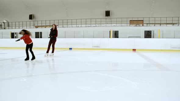 Female Coach Working with Little Figure Skater alt