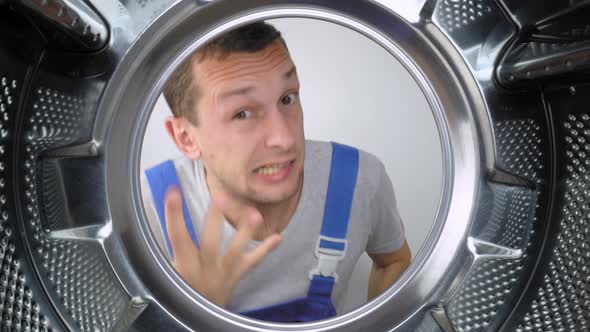 home appliance repairman sticks his head in drum of washing machine and screams alt