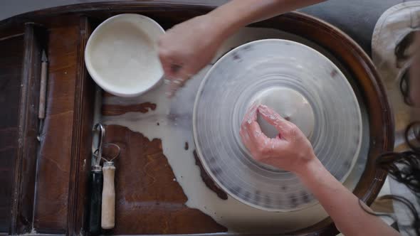Skilled Female Potter is Working with Pottery Wheel in Workshop Top View alt