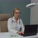 Female Doctor Using Laptop Taking Part in Video Conference Indoors - VideoHive Item for Sale