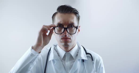Portrait of Shocked Doctor Man is Surprised and Takes Off His Glasses in Shock and Looks at the alt
