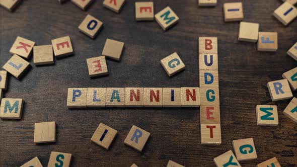 A Phrase PLANNING BUDGET Made of Wooden Blocks with Letters Put Together Perpendicularly alt