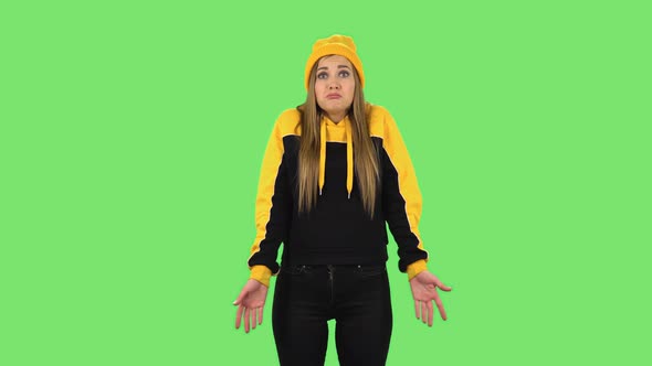 Modern Girl in Yellow Hat Upset Is Shrugging and Sighing. Green Screen alt