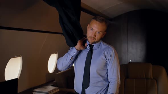 Entrepreneur Throwing a Jacket on His Shoulder in Private Jet. alt