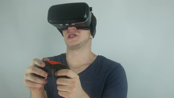 Man Plays a Game in a Virtual Reality Helmet