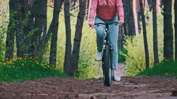 Young Woman on a Bicycle Rides Along a Forest Path in Summer Day Slow Motion alt
