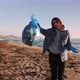 Female collecting plastic garbage on beach, holding plastic bag full of trash. - VideoHive Item for Sale