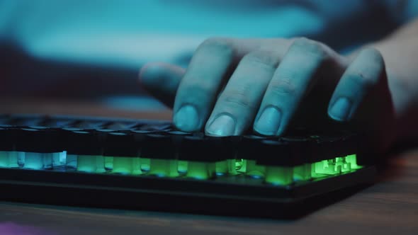 Gamer Typing on Backlight Keyboard Closeup Man Playing Video Game alt