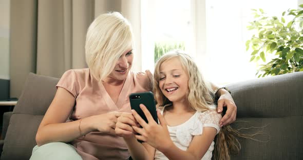 Mother and Daughter Scrolling Smartphone