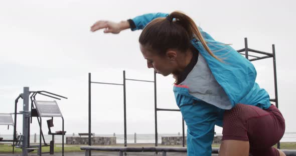 Sporty Caucasian woman exercising in an outdoor gym during daytime alt