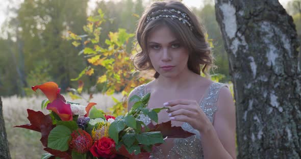 A Young Woman Dressed in a Gray Wedding Dress Celebrates Her Wedding. She Has Flowers in Her Hand alt