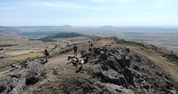 Native Hikers And Pet Dogs On Top Of Rocky Mountain Of Macin In Tulcea County alt