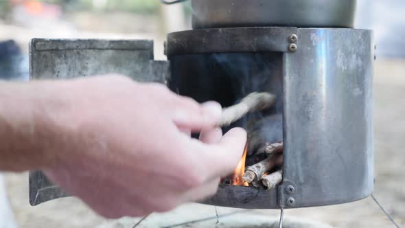 Putting firewood into stove alt