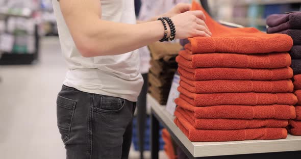 Male Hands Are Choosing a Towel in the Mall