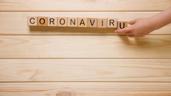 Kids Hand Form Coronavirus Word From Wooden Blocks. Wooden Background. Wooden Toy. Global Spread of