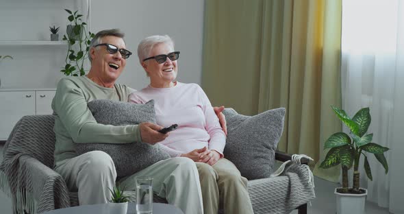 Elderly Couple Grayhaired Grandparents Embracing Sitting on Sofa in Modern Living Room Wearing alt