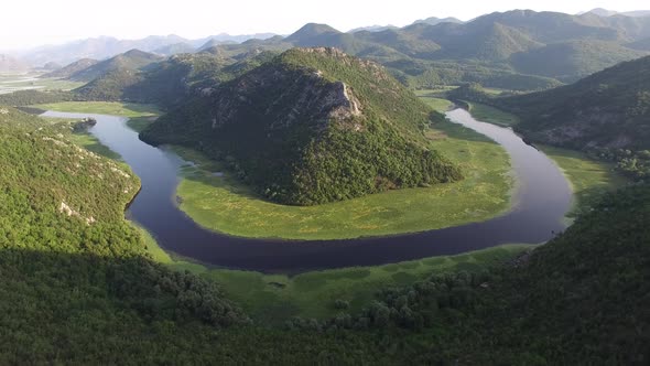 Loopshaped Bend of the Crnojevica River Around a Green Mountain alt