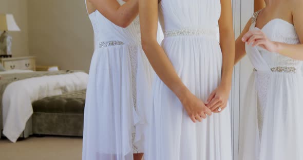 Happy bridesmaids wearing head wreath and getting bride ready 4K 4k alt
